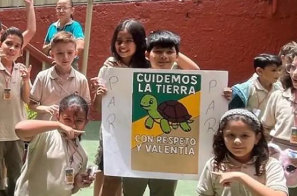 Estudiantes de La Trinidad con un cartel del proyecto Cuidemos la Tierra con respeto y valentía