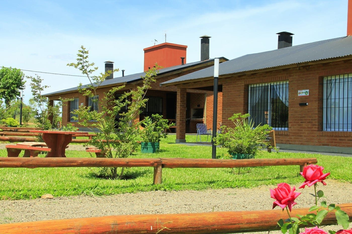 Cabañas de ladrillo con jardín, mesas y parrillas