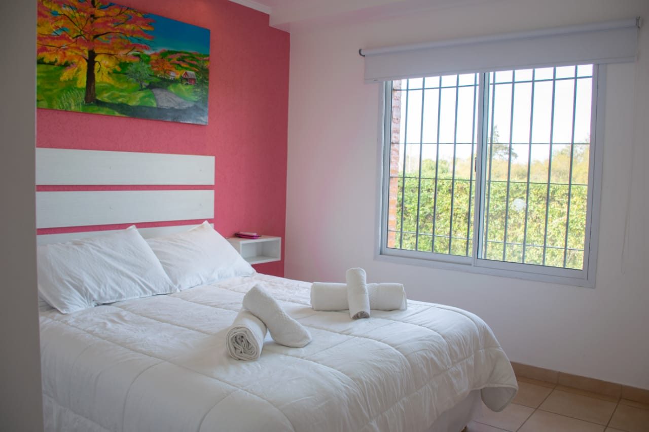 Habitación de cabaña con cama doble y ventana al parque