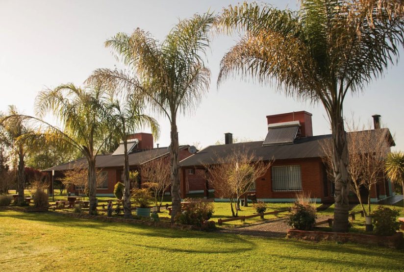 Cabañas de ladrillo con palmeras y parque al atardecer