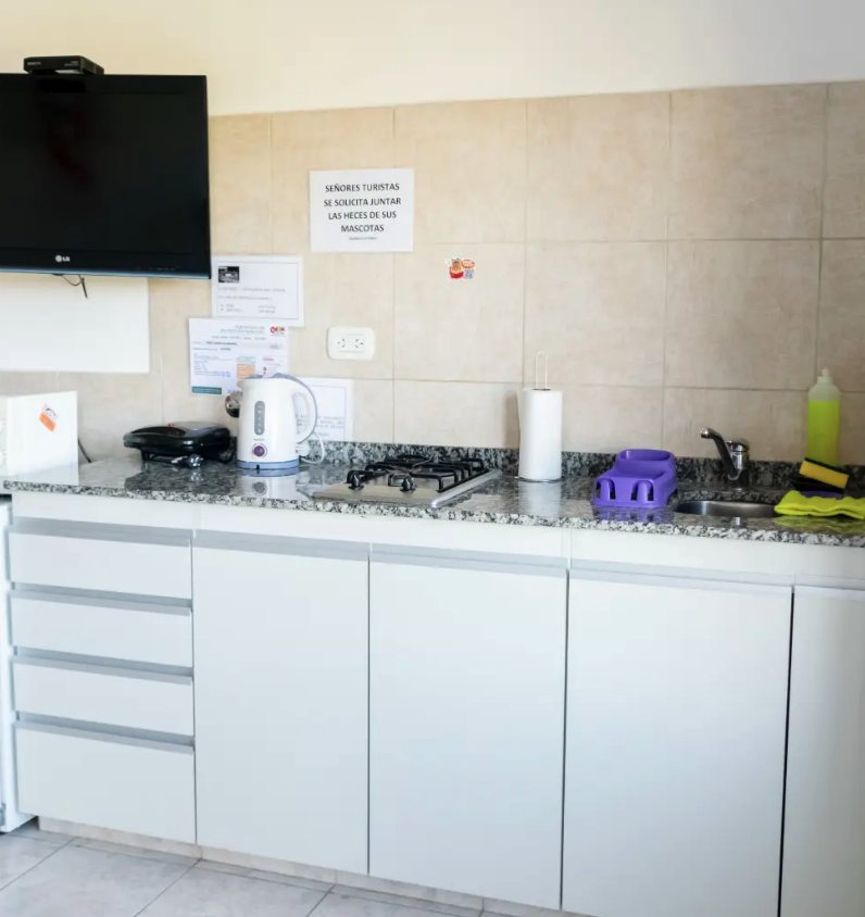 Cocina de monoambiente con anafe, TV y mesada